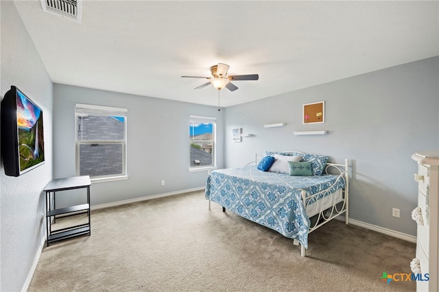 carpeted bedroom featuring baseboards, visible vents, and ceiling fan