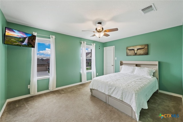 carpeted bedroom with visible vents, baseboards, and ceiling fan