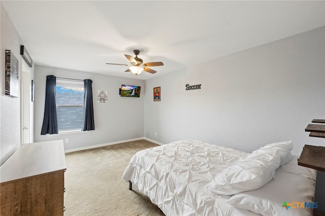 carpeted bedroom featuring baseboards and a ceiling fan