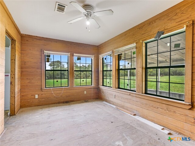 unfurnished sunroom featuring ceiling fan