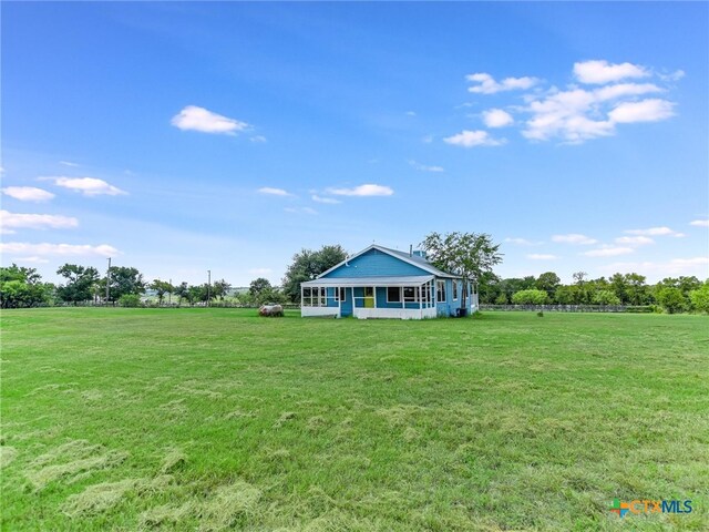 view of yard with a rural view and a porch