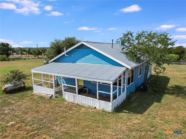 back of house with central AC and a yard