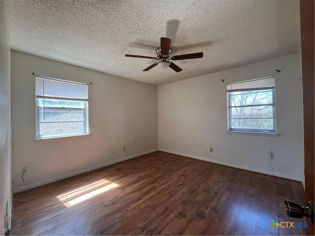 empty room with a ceiling fan, wood finished floors, baseboards, and a textured ceiling