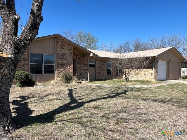 view of front of home with brick siding and a garage