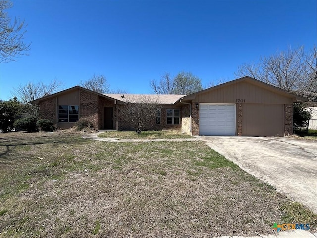 view of front of property featuring a garage, brick siding, and driveway