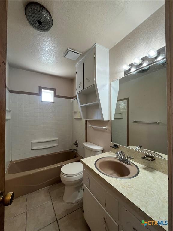 full bath with vanity, tile patterned flooring, a textured ceiling, shower / bathing tub combination, and toilet