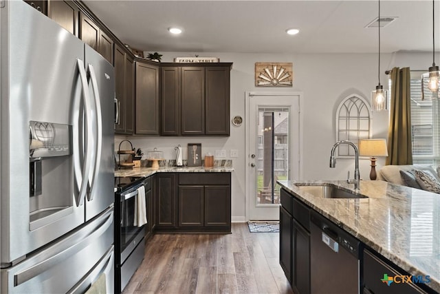 810 Mclaury Cv, Killeen, TX 76542 - kitchen featuring wood finished floors, dark brown cabinets, light stone counters, a sink, and appliances with stainless steel finishes