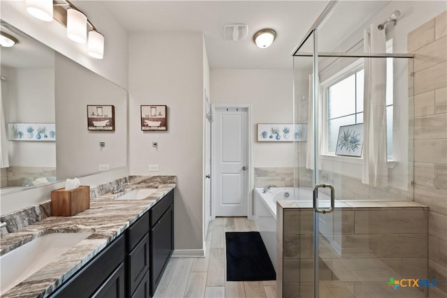 810 Mclaury Cv, Killeen, TX 76542 - full bath featuring double vanity, a garden tub, a shower stall, a sink, and baseboards