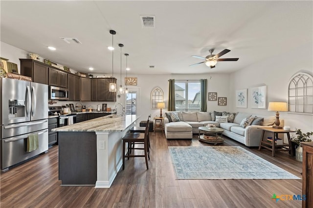 810 Mclaury Cv, Killeen, TX 76542 - interior space with visible vents, dark brown cabinetry, a breakfast bar, ceiling fan, and appliances with stainless steel finishes