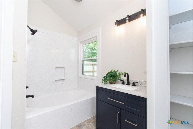 1418 Cedar Ln, Temple, TX 76502 - bathroom with vanity, vaulted ceiling, and washtub / shower combination
