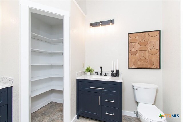 1418 Cedar Ln, Temple, TX 76502 - bathroom with vanity, toilet, a spacious closet, and baseboards