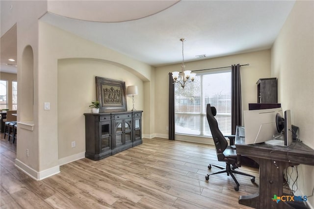 home office featuring light wood-type flooring and an inviting chandelier