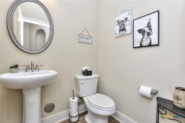 bathroom with toilet and hardwood / wood-style floors