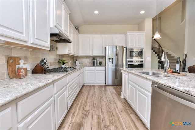 kitchen featuring appliances with stainless steel finishes, sink, white cabinetry, and pendant lighting