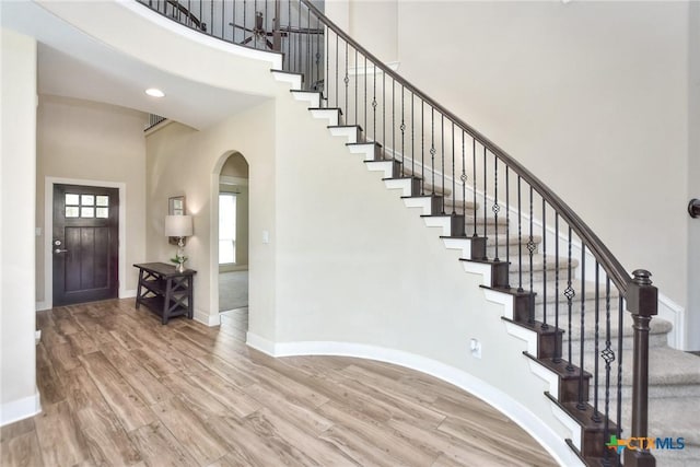 entryway featuring a high ceiling and hardwood / wood-style floors