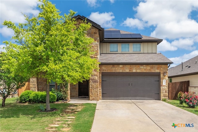 1904 Garretts Way, Manchaca, TX 78652 - view of front of home with stone siding, driveway, board and batten siding, and solar panels