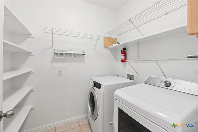 1904 Garretts Way, Manchaca, TX 78652 - laundry room featuring light tile patterned floors, washing machine and clothes dryer, laundry area, and baseboards