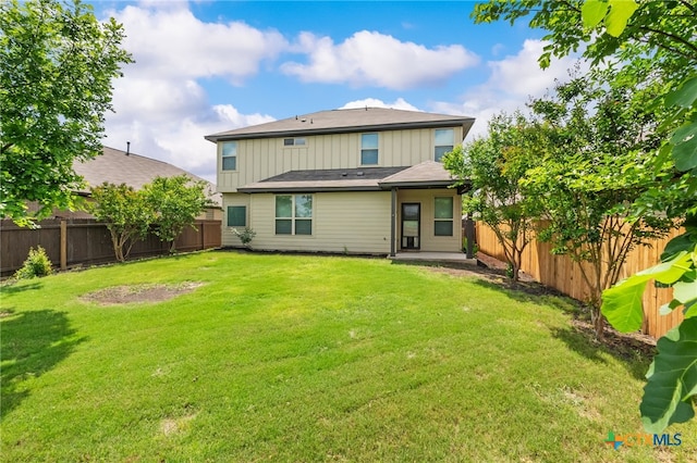 1904 Garretts Way, Manchaca, TX 78652 - rear view of house with a fenced backyard, board and batten siding, and a lawn