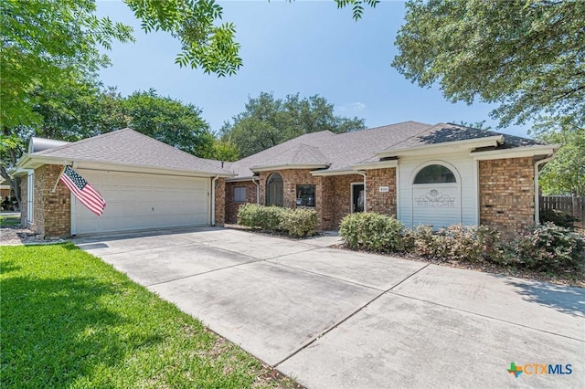 806 Northstar Loop, New Braunfels, TX 78130 - ranch-style home with a garage, brick siding, driveway, a shingled roof, and a front lawn