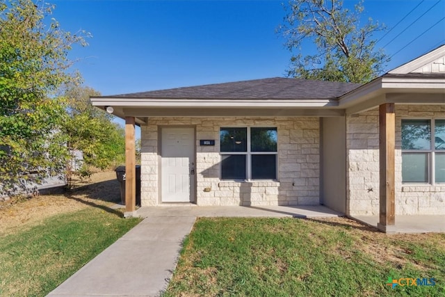 doorway to property with a lawn