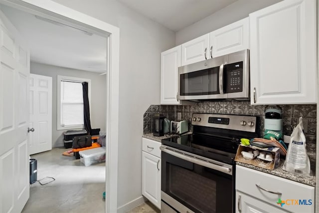 kitchen with dark stone countertops, white cabinets, decorative backsplash, and stainless steel appliances