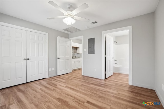 unfurnished bedroom featuring connected bathroom, ceiling fan, sink, and light hardwood / wood-style floors