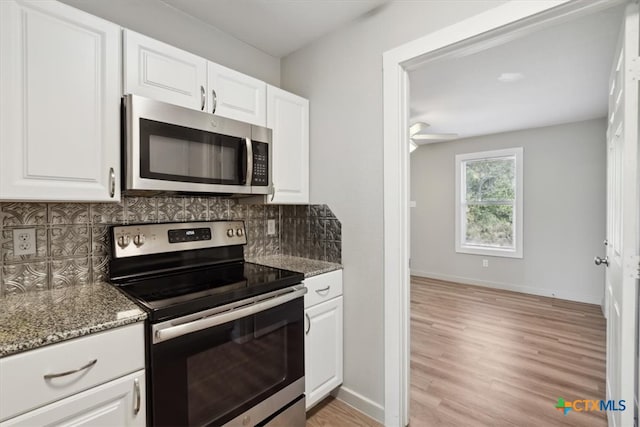 kitchen with white cabinets, decorative backsplash, and appliances with stainless steel finishes