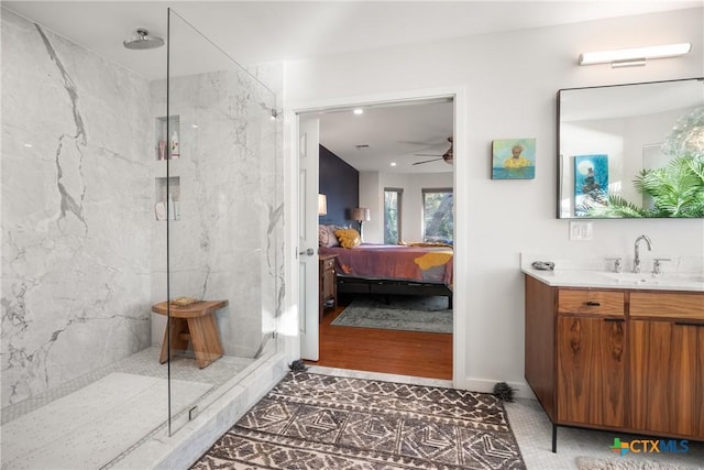 bathroom featuring tiled shower, vanity, and ceiling fan