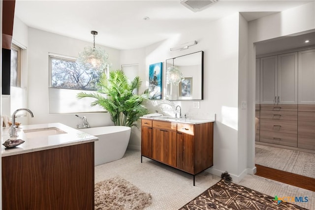 bathroom with vanity, a tub to relax in, tile patterned floors, and a notable chandelier