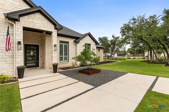 12 Lago Viento Ln, Belton, TX 76513 - entrance to property featuring a lawn, brick siding, and stone siding