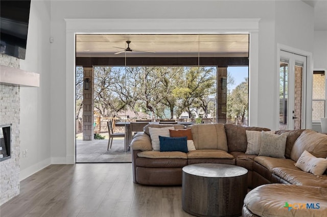12 Lago Viento Ln, Belton, TX 76513 - living room featuring a stone fireplace, ceiling fan, wood finished floors, and a healthy amount of sunlight