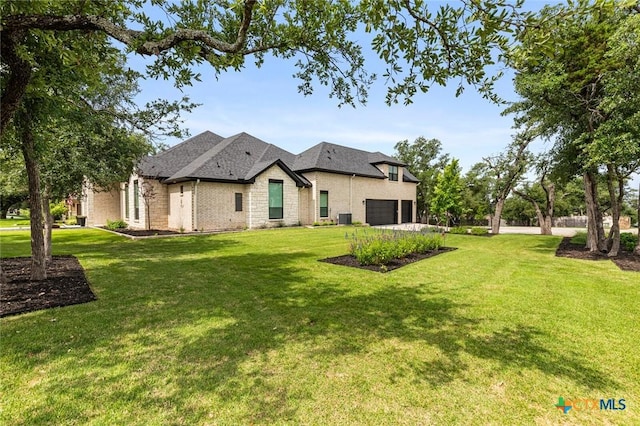 12 Lago Viento Ln, Belton, TX 76513 - rear view of property featuring brick siding, central AC unit, an attached garage, and a yard