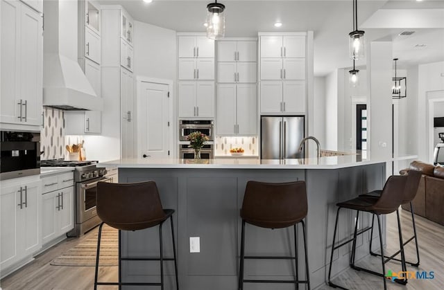 12 Lago Viento Ln, Belton, TX 76513 - kitchen with high end appliances, a breakfast bar, recessed lighting, white cabinets, and light wood-style flooring