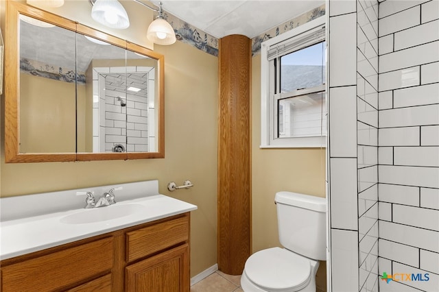 bathroom with vanity, tile patterned floors, toilet, and tiled shower