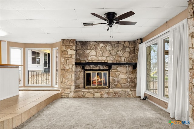 unfurnished living room featuring ceiling fan, a fireplace, and carpet