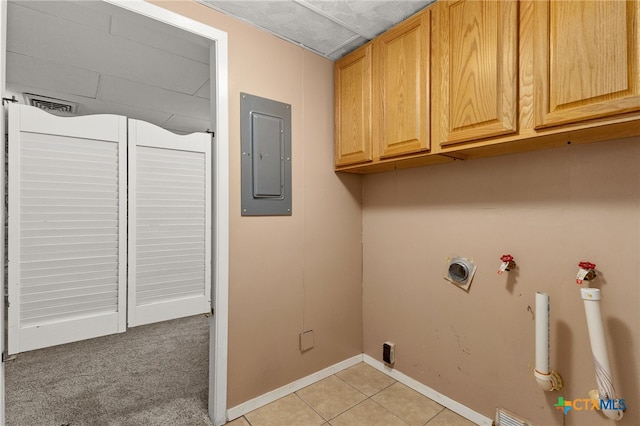 laundry room featuring cabinets, light colored carpet, and electric panel