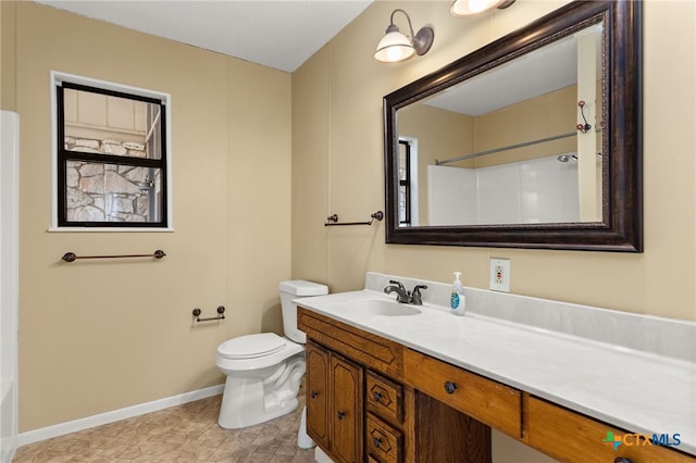 bathroom with vanity, a shower, and toilet