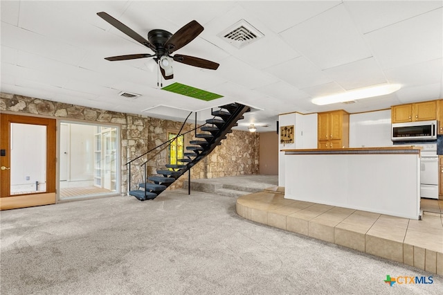 unfurnished living room featuring ceiling fan and light carpet