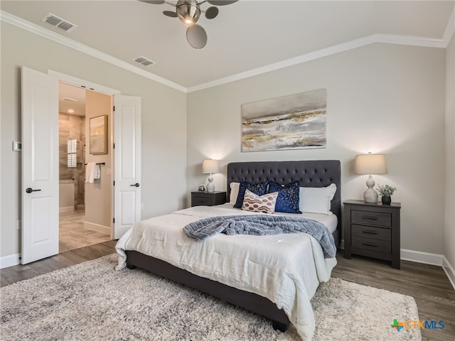 bedroom featuring crown molding, dark wood-type flooring, and ensuite bath