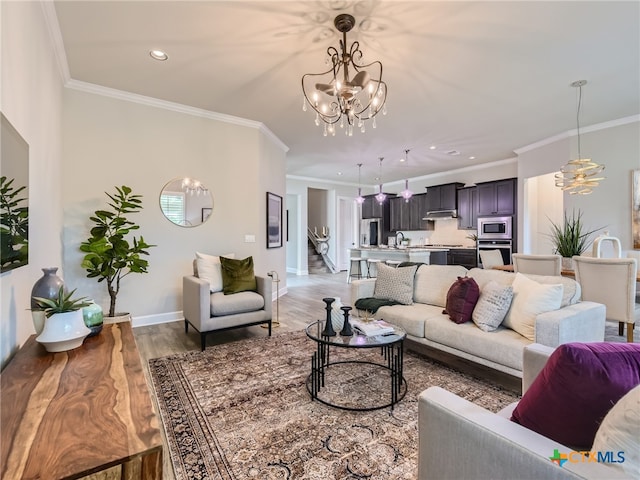 living room with hardwood / wood-style flooring, crown molding, and a notable chandelier