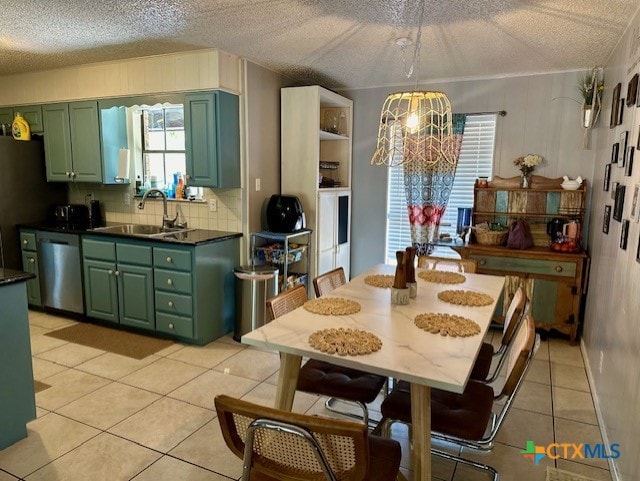 dining space with a textured ceiling, sink, a chandelier, and light tile patterned flooring