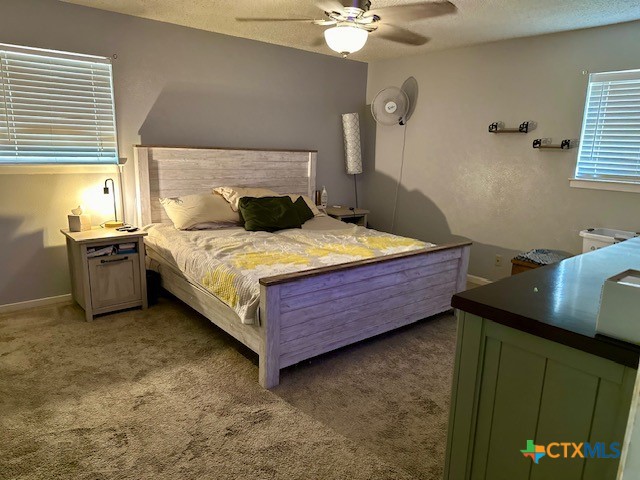 carpeted bedroom with a textured ceiling and ceiling fan