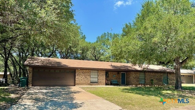 ranch-style house featuring a garage and a front yard