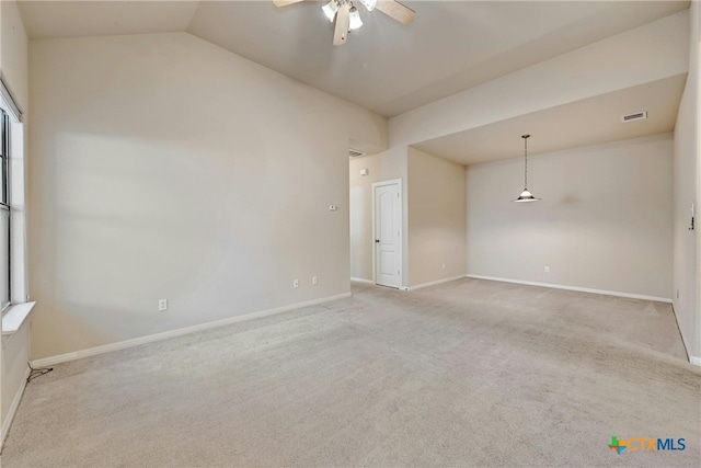 spare room with lofted ceiling, light carpet, and ceiling fan