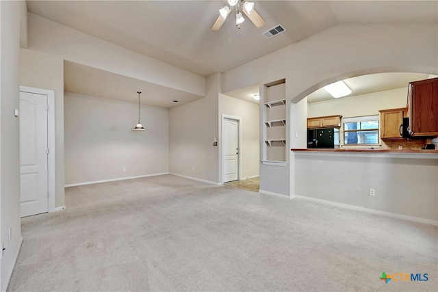 unfurnished living room with vaulted ceiling, light colored carpet, and ceiling fan