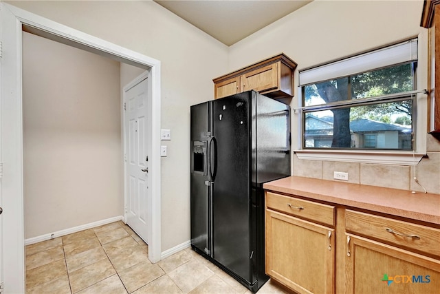 kitchen featuring black fridge with ice dispenser and light tile patterned floors