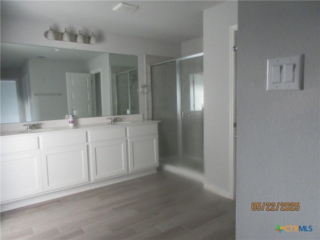 336 Mclintock Rd, Jarrell, TX 76537 - bathroom with double vanity, a shower stall, and wood finished floors
