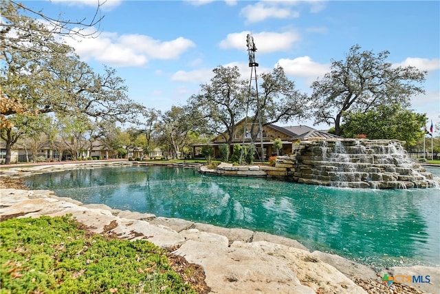 view of pool with a water view and pool water feature