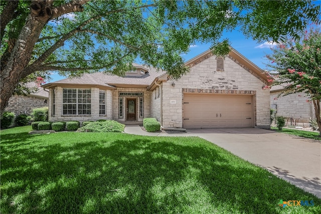 view of front of house featuring an attached garage, stone siding, driveway, and a front lawn