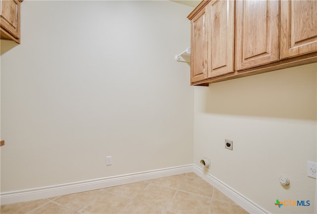 laundry room with cabinets, hookup for a gas dryer, light tile patterned floors, and hookup for an electric dryer